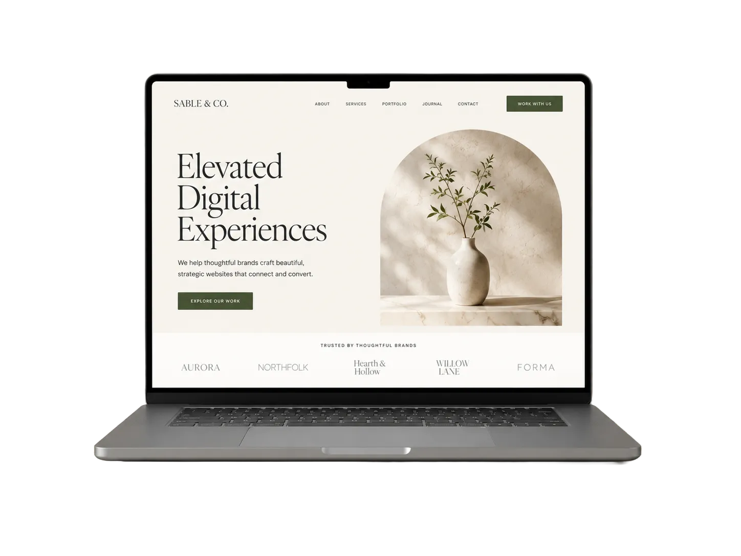 Front-facing grey laptop displaying an editorial website design